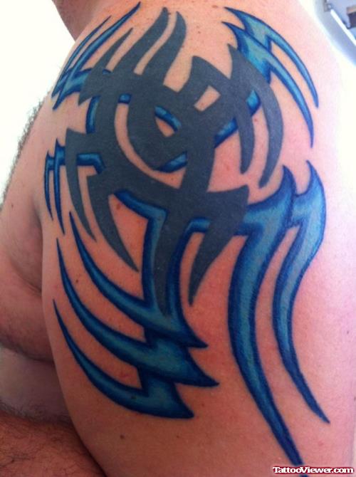 Blue Ink Tribal Tattoo On Man Left Shoulder