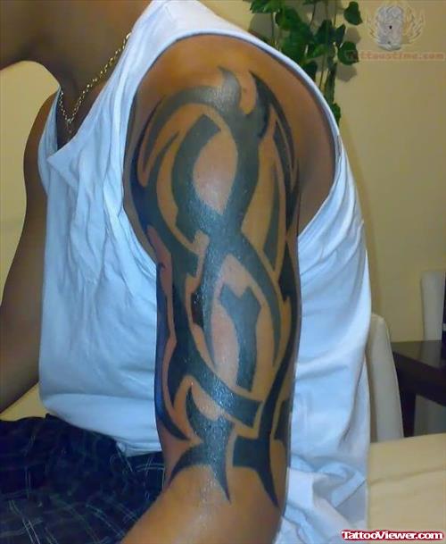 Black Ink Tribal Tattoo On Men Half Sleeve