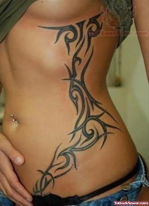 Belly Piercing And Tribal Tattoo On Side