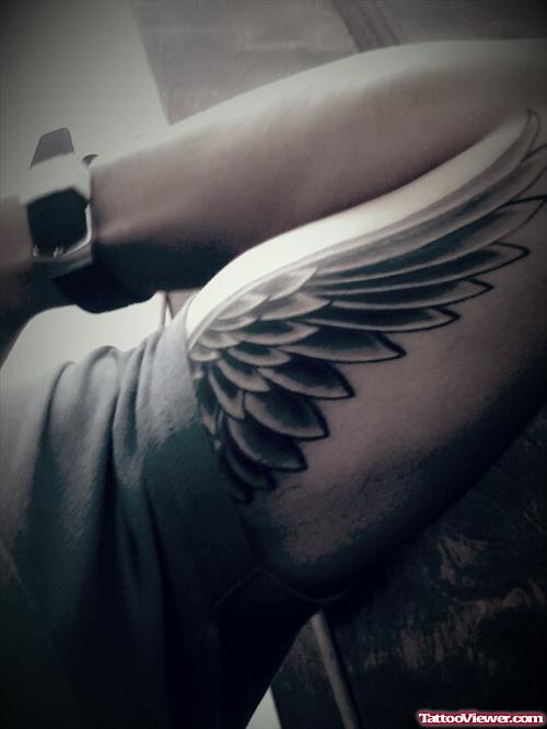 Grey Ink Wing Tattoo On Left Bicep
