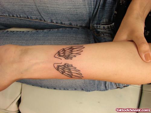 Grey Ink Small Angel Wings Tattoos On Left Forearm