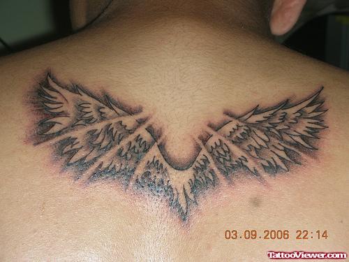Grey Ink Wings Tattoo On Man Upperback