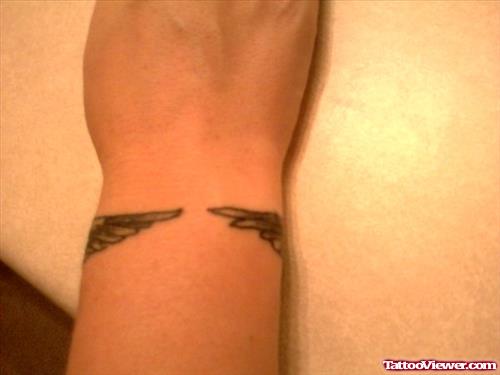 Grey Ink Wings Tattoo On Right Wrist