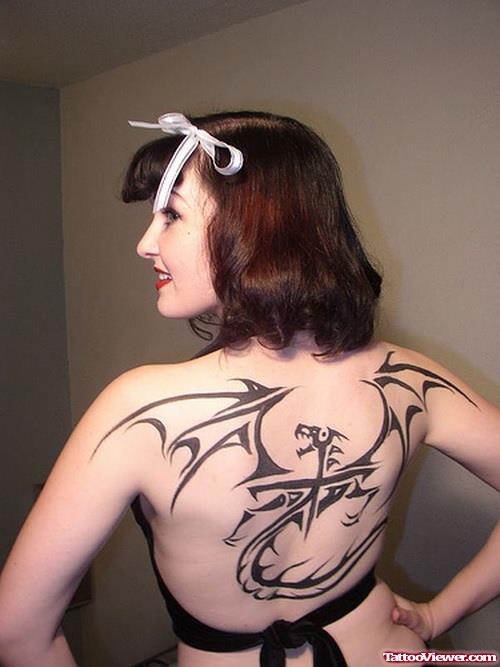 Amazing Black Ink Tribal Dragon Tattoo On Back For Women