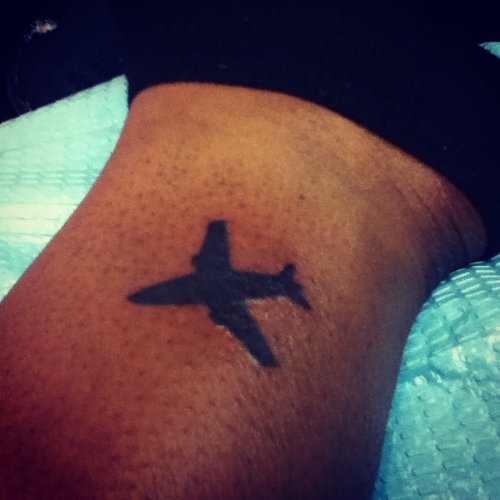 Black Ink Airplane Tattoo On Ankle