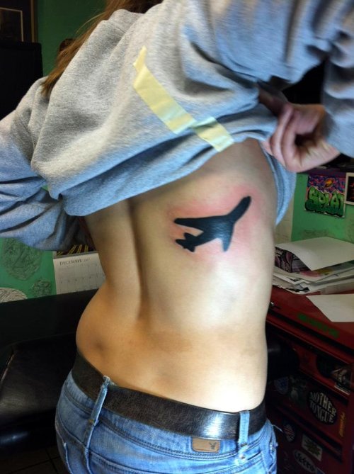 Black Airplane Tattoo On Man Side Rib