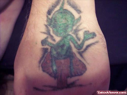 Green Ink Alien Sitting On Mushroom Tattoo