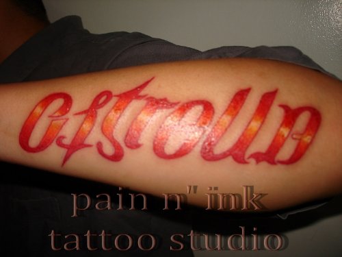 Red Ink Ambigram Tattoo On Left Arm