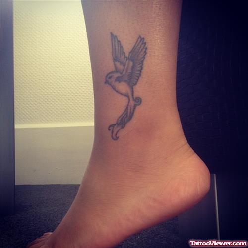 Amazing Grey Ink Flying Bird Ankle Tattoo