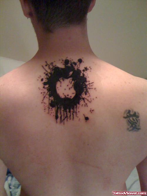 Black Apple Tattoo On Man Upperback