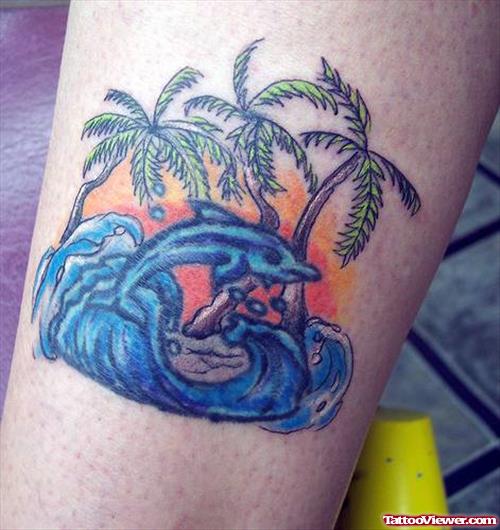 Color Ink Trees And Blue Dolphin Aqua Tattoo On Bicep