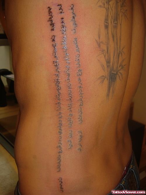 Grey Ink Bamboo Tree And Arabic Tattoo On Side