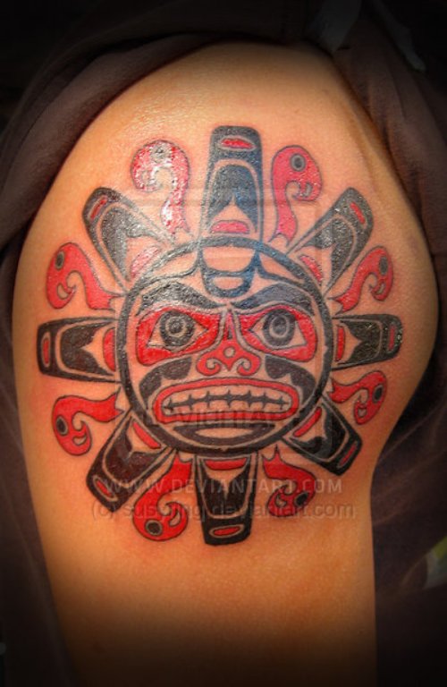 Red And Black Ink Aztec Sun Tattoo On Shoulder