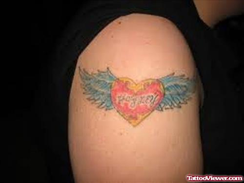 Colored Winged Heart Baby Tattoo On Right Shoulder