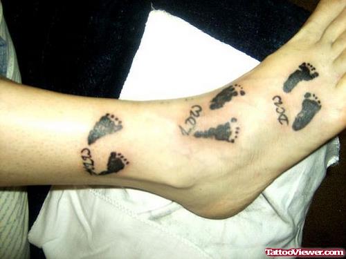 Awesome Black Ink Baby Footprints Tattoos On Ankle