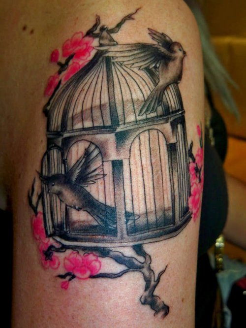 Pink Flowers And Bird Flying From Cage Tattoo