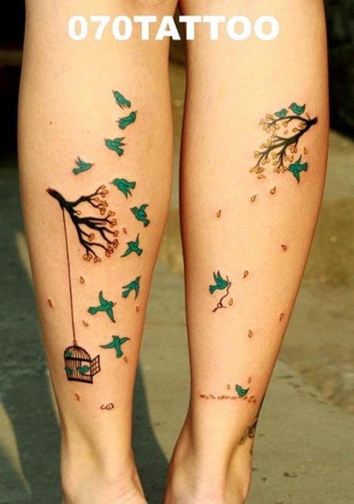 Cage And Green Flying Birds Tattoo On Back Leg