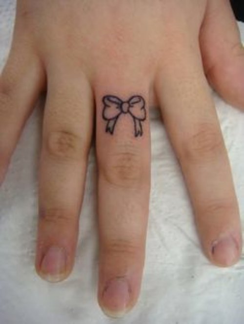 Small Bow Tattoo On Middle Finger