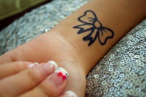 Black Ink Bow Tattoo On Wrist For Girls