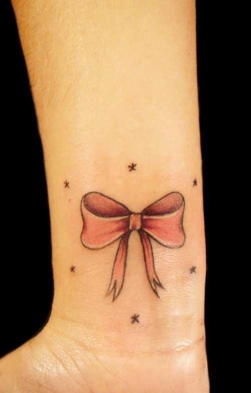 Red Ink Bow Tattoo On Right Wrist