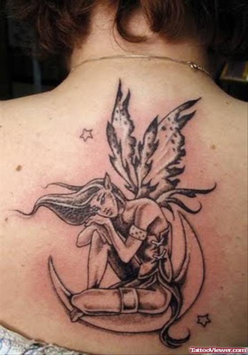 Grey Ink Fairy With Butterfly Wings Sitting On Moon Tattoo On Back