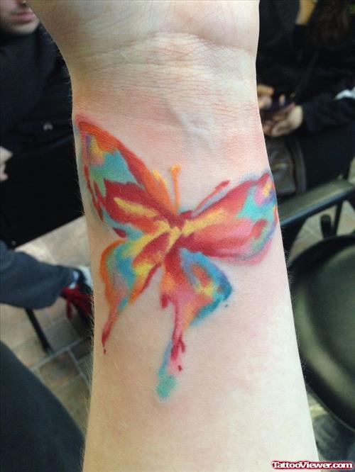 Colorful watercolor butterfly tattoo on arm