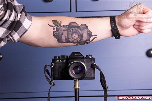 Camera And Green Leaf Tattoo On Arm