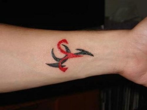 Red And Black Tribal Capricorn Tattoo On Left Forearm