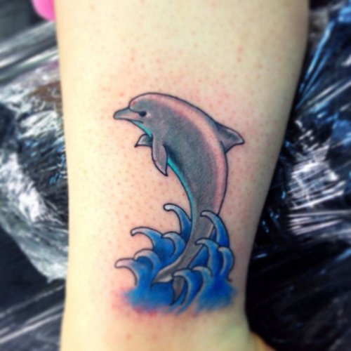 Amazing Blue Water Splash And Dolphin Tattoo