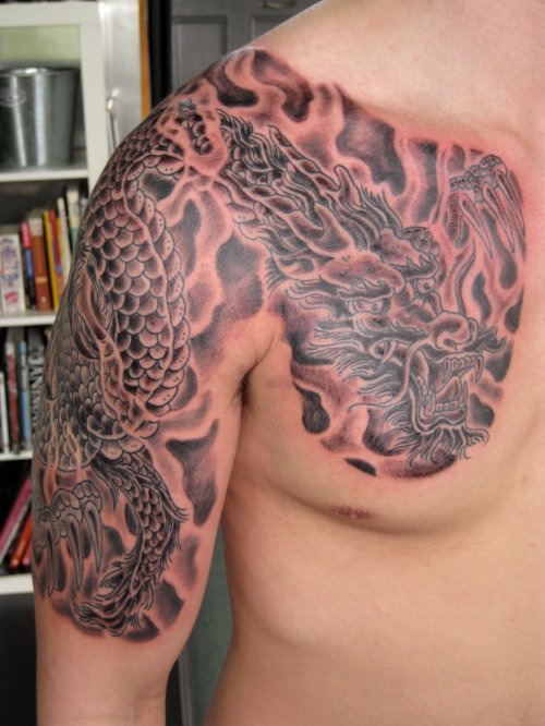 Grey Ink Dragon Tattoo On Chest And Right Half Sleeve