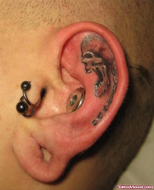 Skull In Ear Tattoo