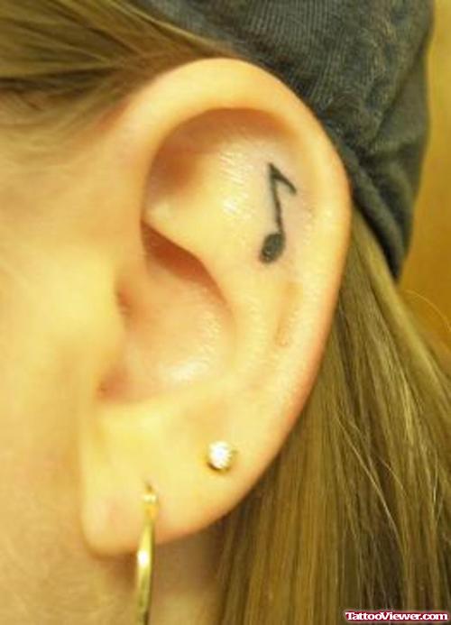 Small Music Note Tattoo On Girl Left Ear