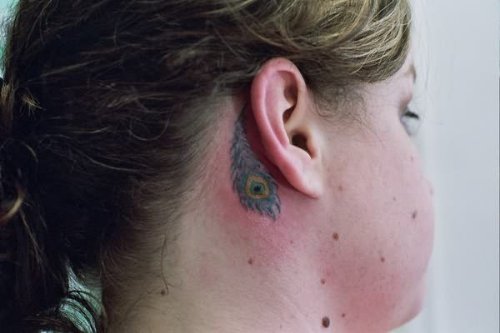 Peacock Feather Tattoo Behind Ear Of Girl