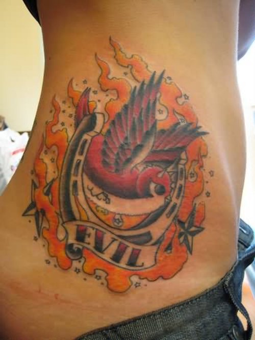 Flaming Horse Shoe And Swallow Tattoo On Side Rib