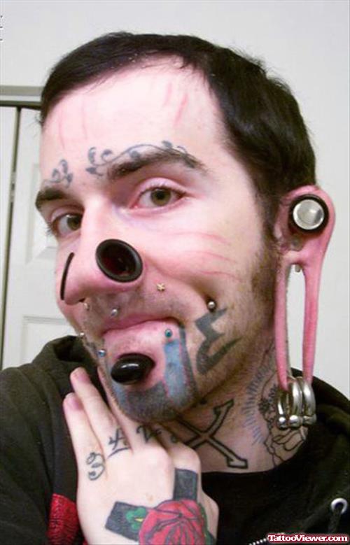 Extreme Colored Tattoo On Face And Left Hand