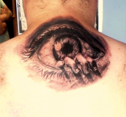 Fingers Coming Out From Eye Tattoo On Upperback