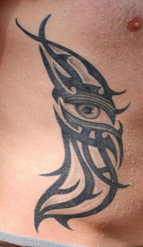 Tribal And Eye Tattoo On Man Side Rib