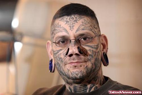 Amazing Grey Ink Tribal Face Tattoo