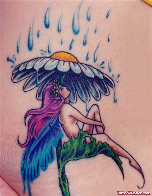 Colored Fairy Tattoo Sitting Under Flower