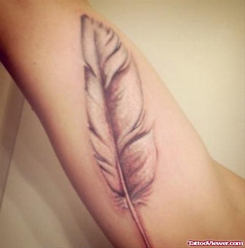 Small Grey Ink Feather Tattoo On Bicep