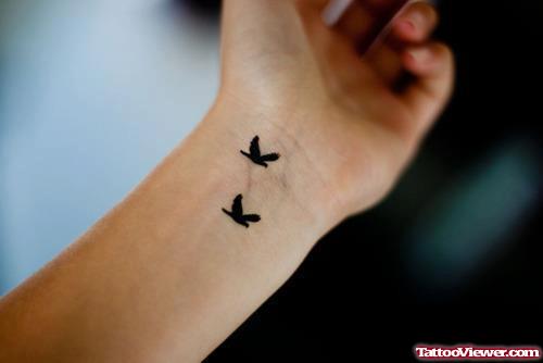 Black Ink Flying Birds Feminine Tattoo On Wrist