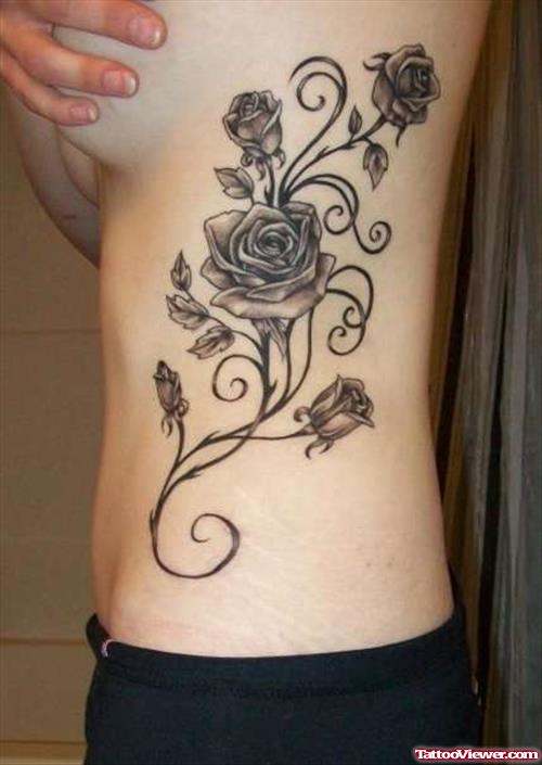 Grey Ink Feminine Flower Tattoo On Side Rib