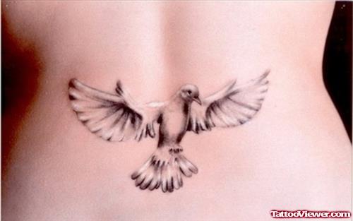 Grey Ink Flying Dove Feminine Tattoo On Lowerback
