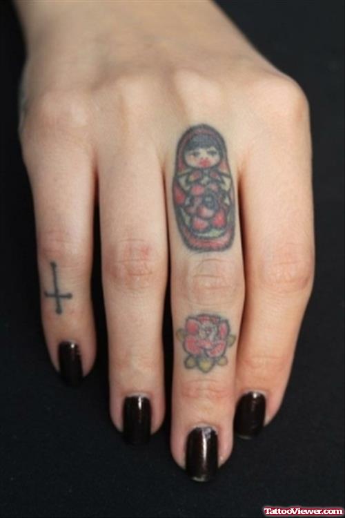 Red Flower, Cross And Matryoshka Finger Tattoos