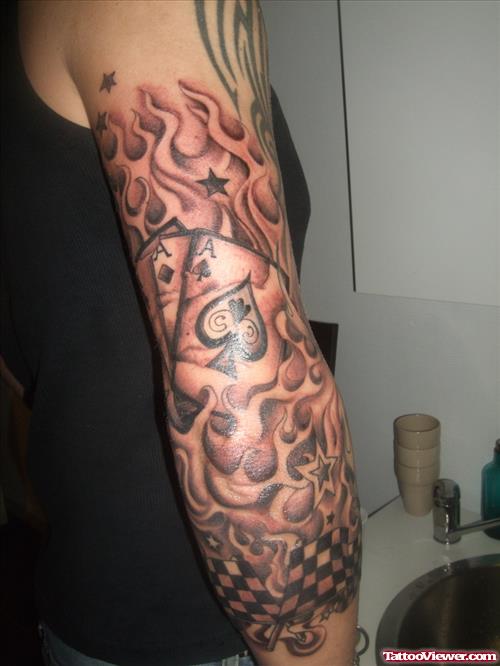 Grey Ink Cards And Fire And Flame Tattoo On Sleeve