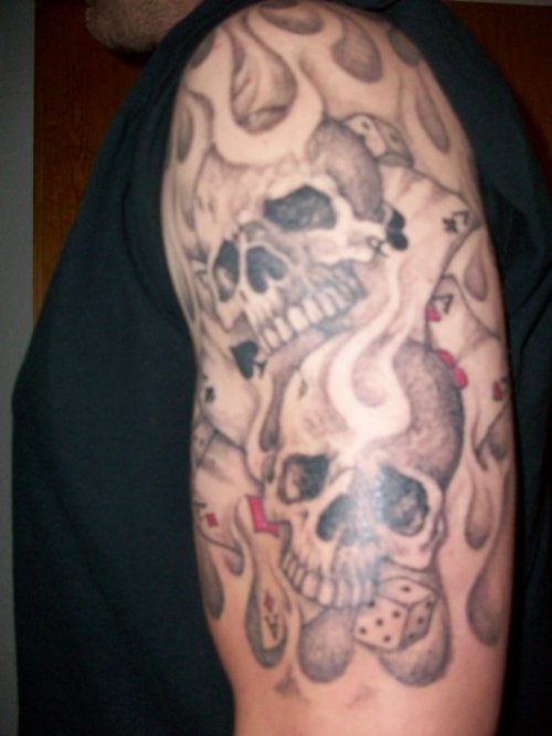 Grey Ink Flaming Skulls Tattoo On Half Sleeve