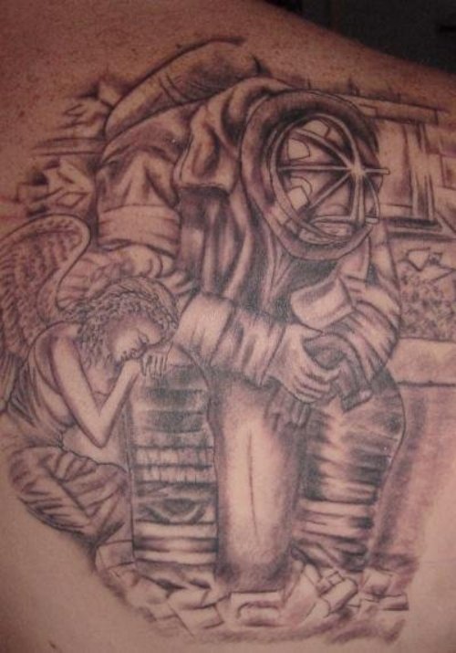 Grey Ink Sad Angel And Firefighter Tattoo On Back Shoulder