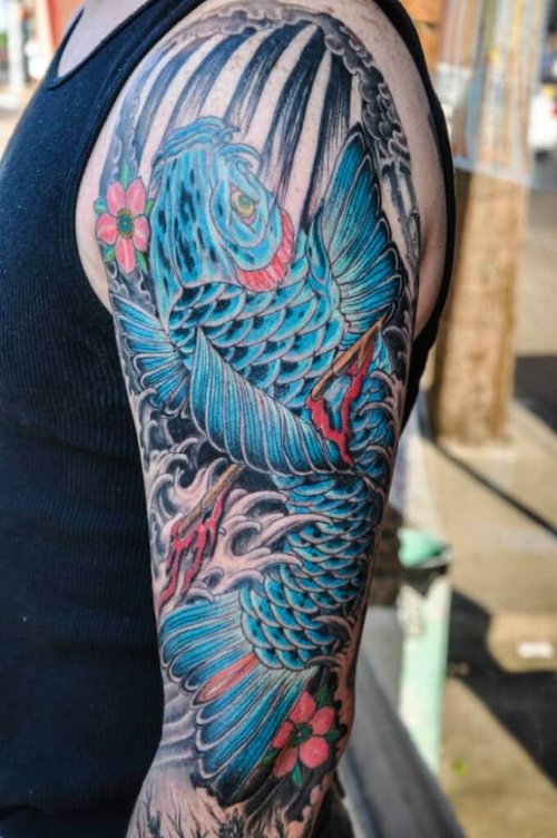 Blue Ink Fish Tattoo On Left Sleeve