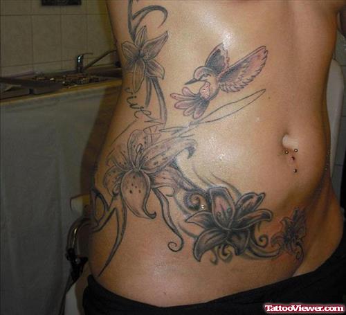 Flying Hummingbird And Flower Tattoos On Rib Side