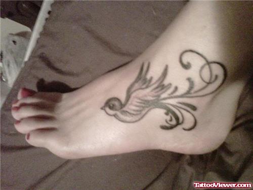 Black Ink Flying Swallow Bird Tattoo On Left Foot